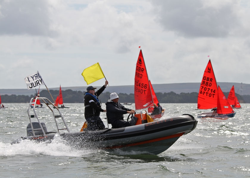 A Jury RIB at speed with jury member waving yellow flag